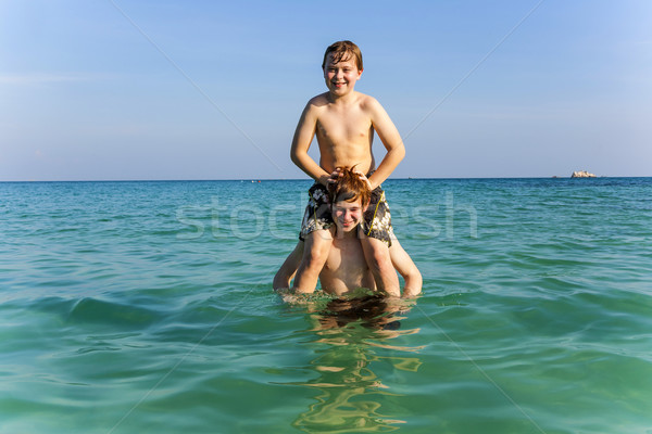 brothers are enjoying the clear warm water in the ocean and play Stock photo © meinzahn
