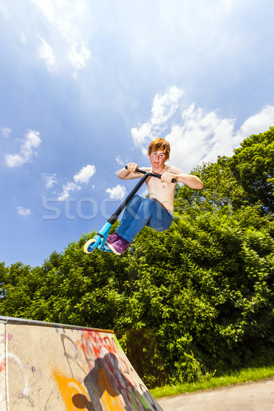 young boy going airborne with a scooter Stock photo © meinzahn