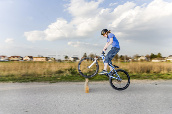 Jugendlicher übt Tricks, Sprünge mit dem Bike auf der Strasse Stock photo © meinzahn