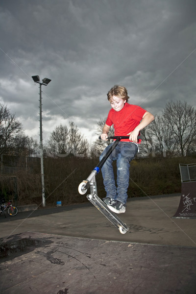 Boy going airborne with a scooter Stock photo © meinzahn