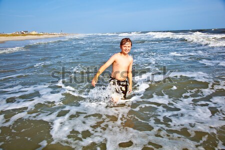 Stock photo: young boy enjoys the waves of the blue sea