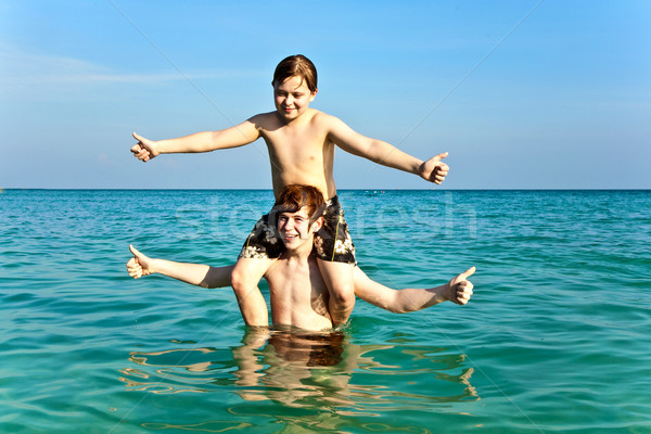 Stock photo: brothers are enjoying the clear warm water at the beautiful beac