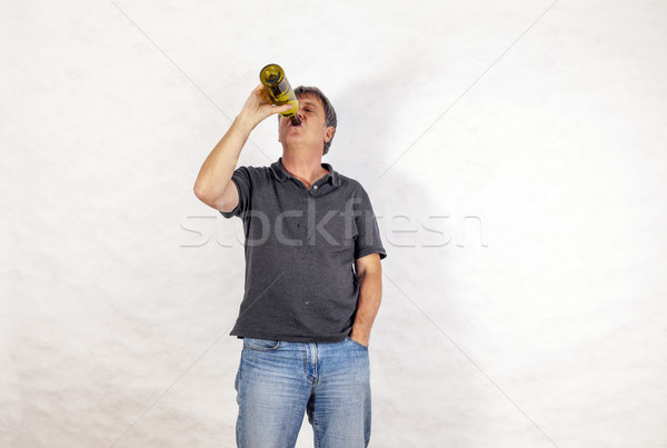 man drinks alcohol out of a bottle Stock photo © meinzahn