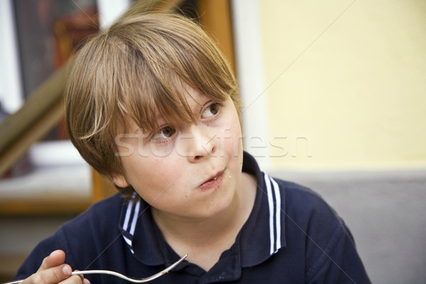 eating boy is looking astonished and interested  Stock photo © meinzahn
