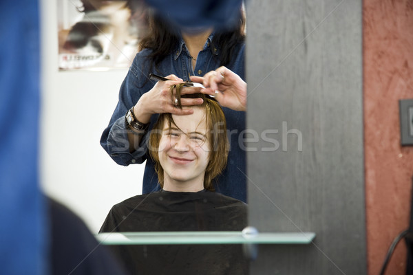 smiling young boy with red hair at the hairdresser Stock photo © meinzahn