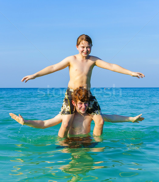 brothers enjoying the clear warm water and play piggyback Stock photo © meinzahn