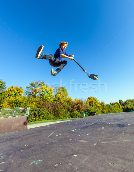Stock photo: child going airborne with  scooter