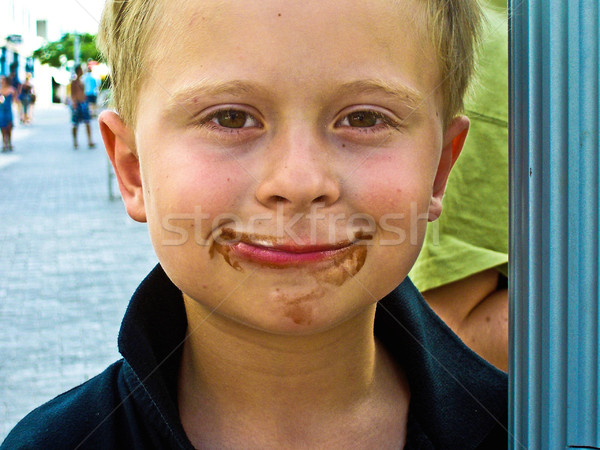 child has chocolate around his mouth and smiles Stock photo © meinzahn