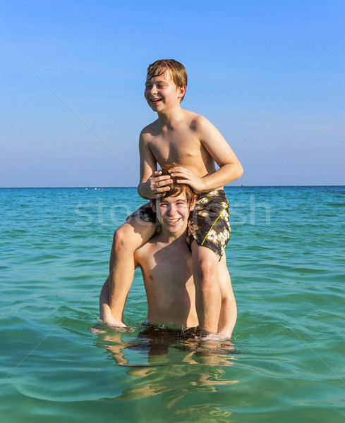 Stock photo: brothers are enjoying the clear warm water in the ocean and play