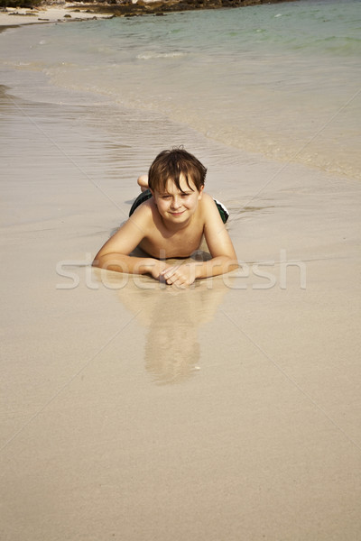 boy iy lying at the beach and enjoying the warmness of the water Stock photo © meinzahn