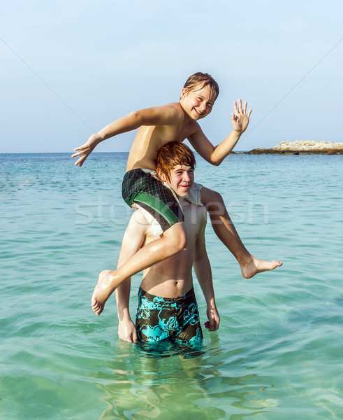 brothers playing piggyback in the ocean Stock photo © meinzahn