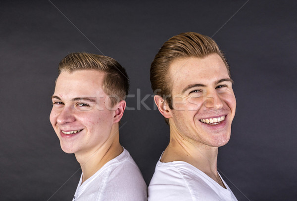 two teenage boys standing back to back and have fun Stock photo © meinzahn
