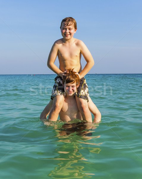 brothers are enjoying the clear warm water in the ocean and play Stock photo © meinzahn