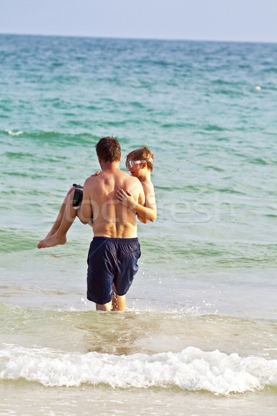 father is holding his son in the arms at the beautiful sandy bea Stock photo © meinzahn