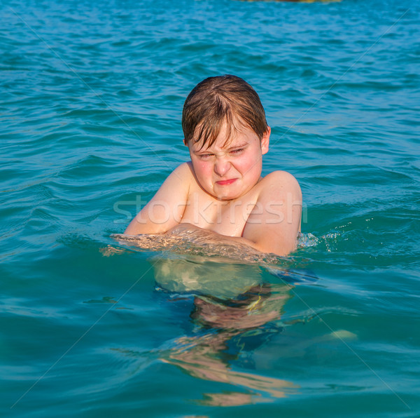 boy enjoys the clear warm water  but looks angry Stock photo © meinzahn