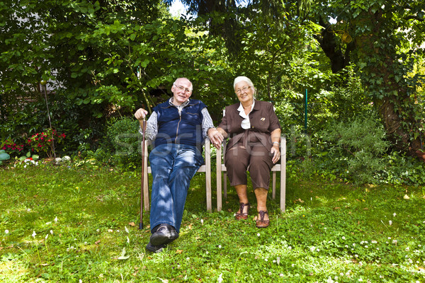 Starszych para posiedzenia strony ogród rodziny Zdjęcia stock © meinzahn