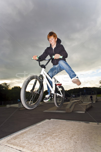 joung red haired boy is jumping with his BMX Bike Stock photo © meinzahn