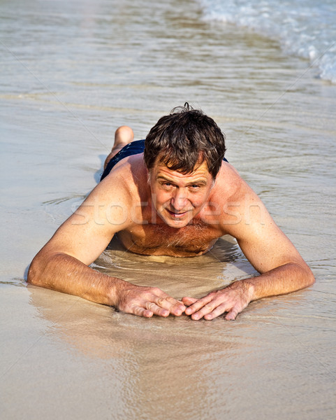 Man in bathingsuit lying at the beach  Stock photo © meinzahn