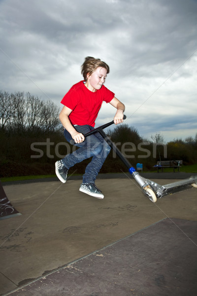 Boy going airborne with a scooter Stock photo © meinzahn