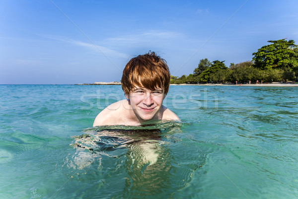 red haired boy enjoys the crystal clear water in the sea Stock photo © meinzahn