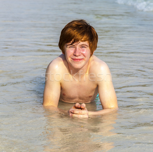 boy enjoys lying in the spume of the tropical beach  Stock photo © meinzahn