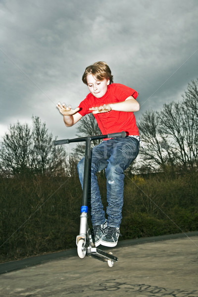 Boy going airborne with a scooter Stock photo © meinzahn
