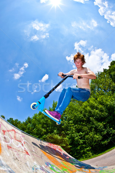 young boy going airborne with a scooter Stock photo © meinzahn