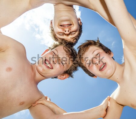 Low angle view of happy guys  standing together in a circle agai Stock photo © meinzahn