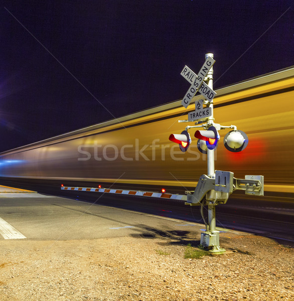 Railroad crossing with passing train by night  Stock photo © meinzahn