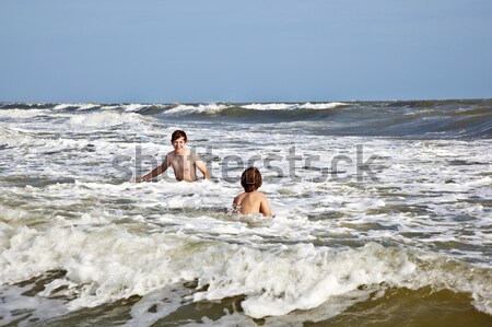 boys enjoying the waves in the wild ocean Stock photo © meinzahn