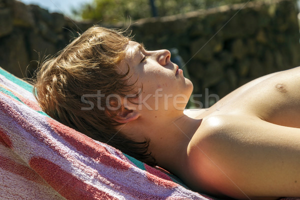 cute handsome teenage boy rests on a beach couch at the pool Stock photo © meinzahn