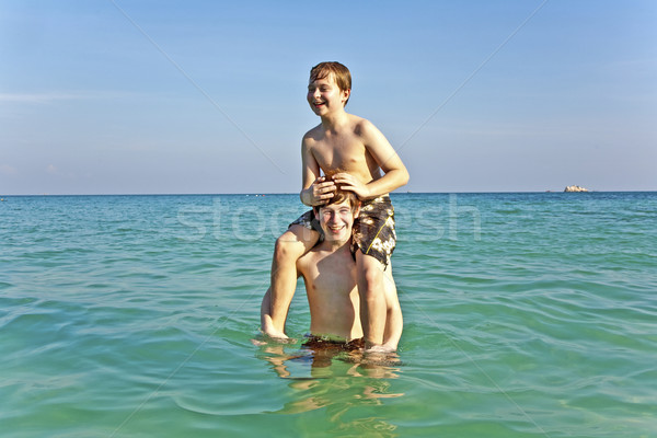 brothers are enjoying the clear warm water at the beautiful beac Stock photo © meinzahn
