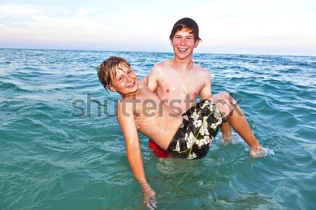 brothers have joy playing piggyback in the clear ocean Stock photo © meinzahn