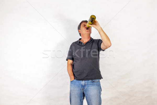 man drinks alcohol out of a bottle Stock photo © meinzahn