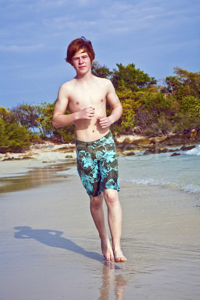 young boy with red hair in swimsuit is running along the beautif Stock photo © meinzahn