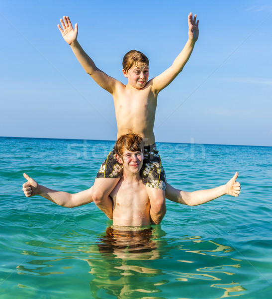 brothers are enjoying the clear warm water in the ocean and play Stock photo © meinzahn