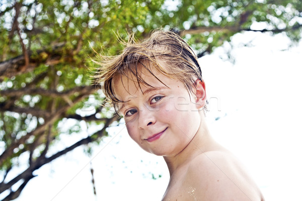 young boy at the beach is smiling and looking self confident Stock photo © meinzahn
