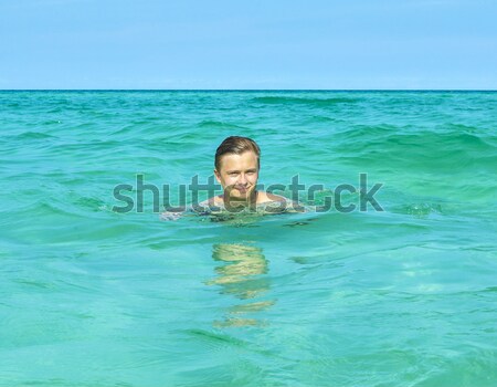 boy is swimming on his surfboard  Stock photo © meinzahn