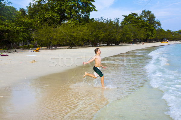 young happy boy with brown hair enjoys  jumping in the beautiful Stock photo © meinzahn