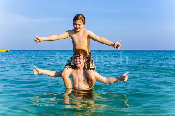 brothers are enjoying the clear warm water in the ocean and play Stock photo © meinzahn