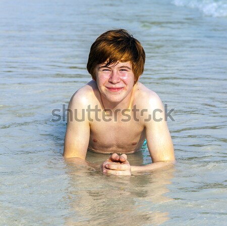 boy enjoys lying in the spume of the tropical beach  Stock photo © meinzahn