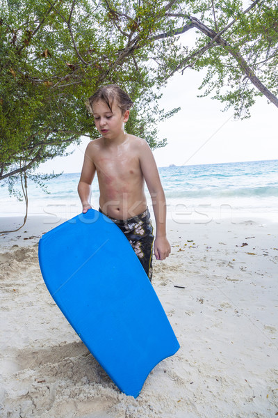 young boy at the beach is exhausted from surfing  Stock photo © meinzahn