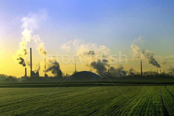 industry landscape in sunrise with smoking chimneys Stock photo © meinzahn