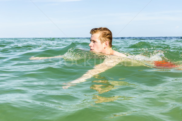 Tizenéves fiú úszik óceán tengerpart víz biztonság Stock fotó © meinzahn