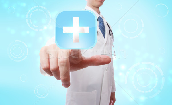 Medical doctor pushing a medical cross symbol icon Stock photo © Melpomene