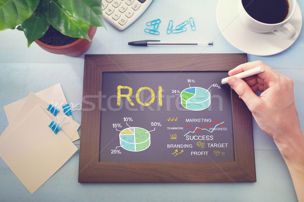 Man drawing ROI concept on chalkboard Stock photo © Melpomene