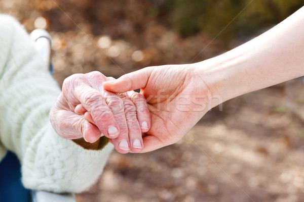 Senior Lady Holding Hands with Young Caretaker Stock photo © Melpomene