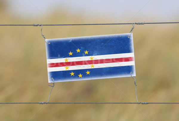 Border fence - Old plastic sign with a flag Stock photo © michaklootwijk