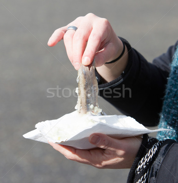 Stock photo: Dutch woman is eating typical raw herring