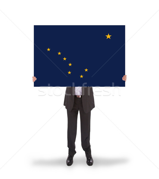 Smiling businessman holding a big card, flag of Alaska Stock photo © michaklootwijk